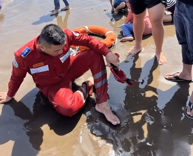 Anh Phạm Công Hậu, ngồi thở dốc sau khi vật lộn với thủy triều để đưa em Đ. vào bờ an toàn