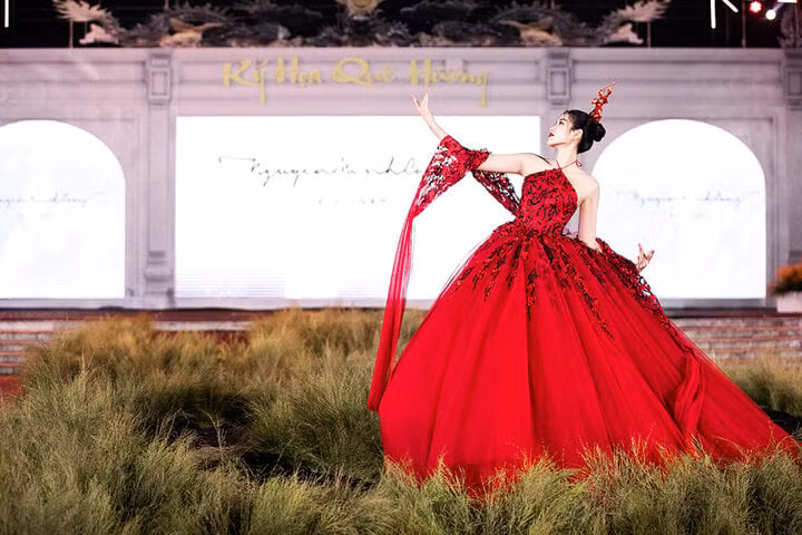 Hoa hậu Đỗ Thị Hà gây chú ý khi đảm nhận vị trí vedette cho BST này. Khoác lên mình thiết kế kết hợp giữa áo yếm cùng váy bồng bềnh, Đỗ Thị Hà khoe nhan sắc lộng lẫy với trang phục đỏ rực.