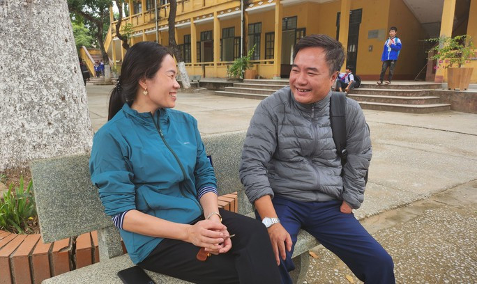 25 năm đạp xe dạy học và chuyện tình đẹp - Ảnh 2. Vợ chồng thầy Hương trò chuyện dưới sân trường trong giờ giải lao.