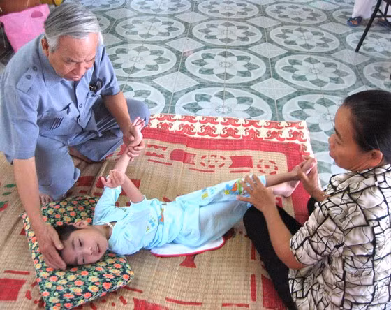 Ông Lê Văn Hoan thăm một cháu bé được phục hồi chức năng