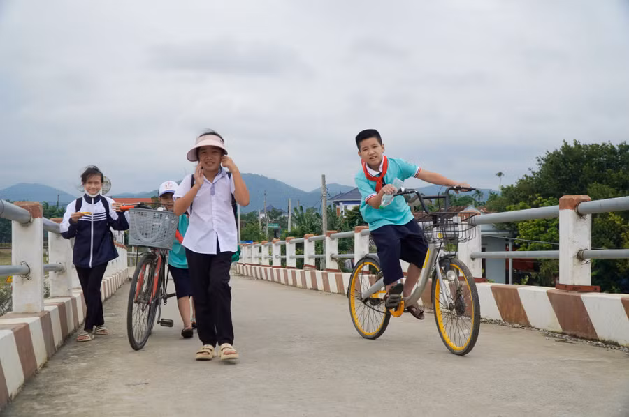 Những đứa trẻ ở Cồn Quan (xã Quảng Trung, TX.Ba Đồn, Quảng Bình) đi học dễ dàng qua cầu Công Hòa. Ảnh: Nguyễn Phúc