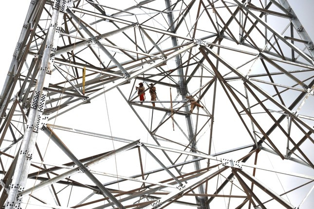 Công nhân căng mình giữa nắng nóng lắp đặt từng cấu kiện cột 329. Ảnh: Cảnh Huệ Công nhân căng mình giữa nắng nóng lắp đặt từng cấu kiện cột 329. Ảnh: Cảnh Huệ