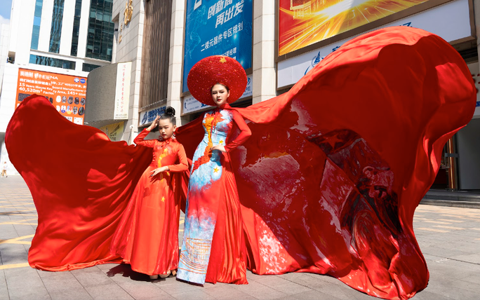 NTK Thạch Linh cùng mẫu nhí Thiệu Vy mang áo dài bản đồ Việt Nam ra nước ngoài - Ảnh 3. Mẫu nhí Nguyễn Lý Thiệu Vy chụp ảnh cùng NTK Thạch Linh