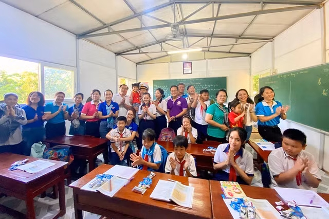 Các đại biểu đoàn công tác chụp hình lưu niệm với các em học sinh ở Hòn Chuối. Ảnh: THU NGÂN