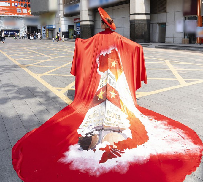 NTK Thạch Linh cùng mẫu nhí Thiệu Vy mang áo dài bản đồ Việt Nam ra nước ngoài - Ảnh 2. Chiếc áo dài được thiết kế với hình ảnh cờ đỏ sao vàng, chiến sĩ đang bảo vệ vùng biển đảo Tổ quốc và nổi bật nhất là bản đồ Việt Nam với hình ảnh quần đảo Hoàng Sa, Trường Sa