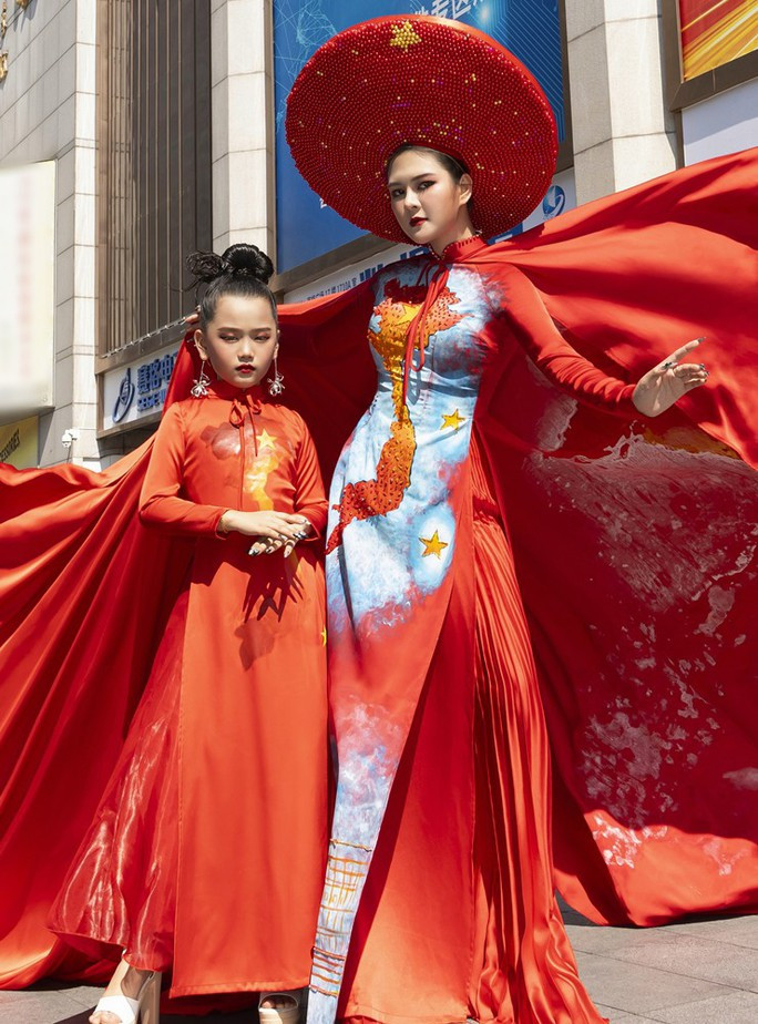 NTK Thạch Linh cùng mẫu nhí Thiệu Vy mang áo dài bản đồ Việt Nam ra nước ngoài - Ảnh 1. NTK Thạch Linh cùng mẫu nhí Thiệu Vy với áo dài bản đồ Việt Nam tại Trung Quốc