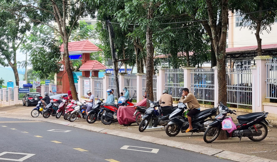 Phụ huynh xếp hàng ngay ngắn trên vỉa hè để chờ đón con tan học. Ảnh: H.P Phụ huynh xếp hàng ngay ngắn trên vỉa hè để chờ đón con tan học. Ảnh: H.P