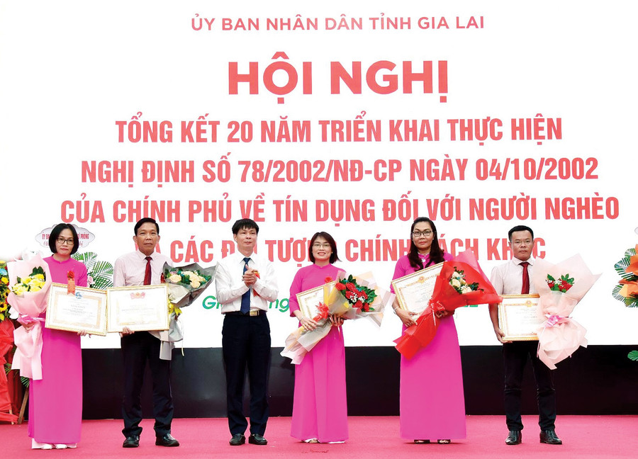 Trưởng ban Kiểm soát Ngân hàng CSXH Việt Nam Nguyễn Mạnh Tú trao quyết định khen thưởng cho các cá nhân có thành tích xuất sắc trong 20 năm thực hiện tín dụng chính sách theo Nghị định số 78 của Chính phủ. Ảnh: Sơn Ca