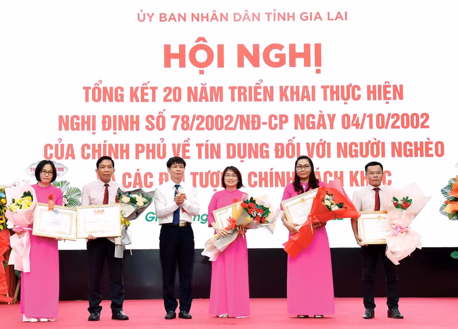 Trưởng ban Kiểm soát Ngân hàng CSXH Việt Nam Nguyễn Mạnh Tú trao quyết định khen thưởng cho các cá nhân có thành tích xuất sắc trong 20 năm thực hiện tín dụng chính sách theo Nghị định số 78 của Chính phủ. Ảnh: Sơn Ca