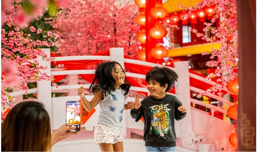 Trẻ em tạo dáng chụp ảnh với đồ trang trí cho tết Nguyên đán tại một trung tâm mua sắm ở Kuala Lumpur, Malaysia vào ngày 18.1.2023. Ảnh: Chụp màn hình Tân Hoa Xã