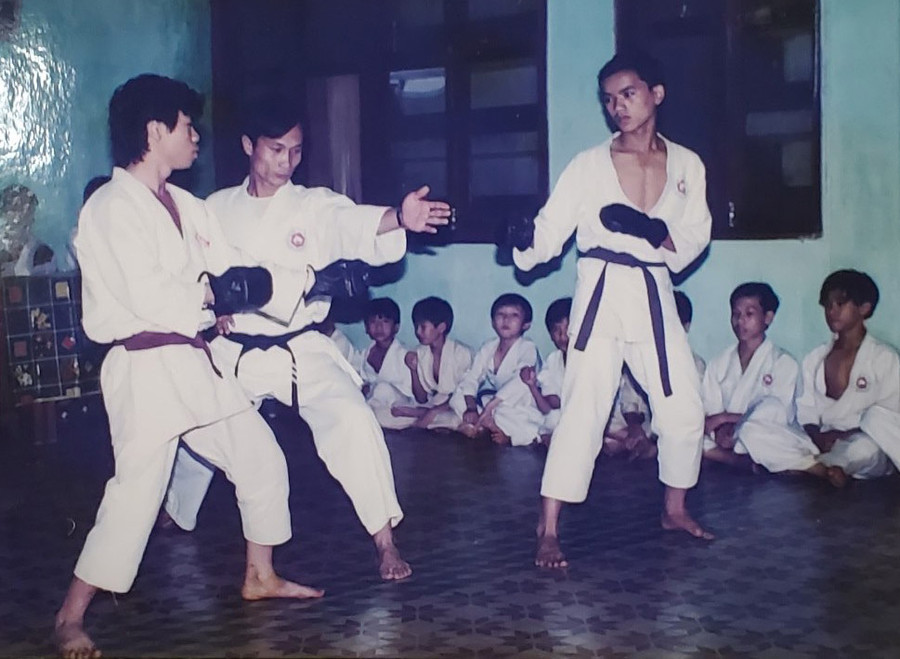 Ông Lê Vĩnh Lợi (đứng giữa) làm trọng tài cho 2 võ sinh trong lớp võ đầu tiên ở Gia Lai thi đấu nâng đai. Ảnh: Nguyễn Tú