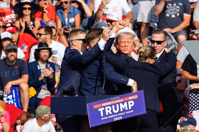 Mật vụ Mỹ chạy lên sâu khấu ngay khi cựu Tổng thống Donald Trump trúng đạn tại sự kiện vận động tranh cử hôm 13-7 ở TP Butler. Ảnh: New York Times