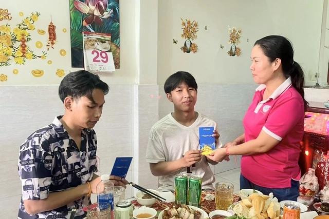 Nhân dịp tết Lào, bà Võ Thị Bé Sáu lì xì cho 2 cậu con trai Souliyavongsak Kenthsana (bìa trái) và Sitthinalongsy Sackda