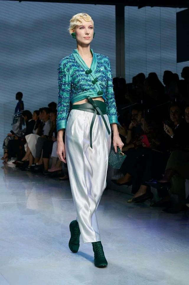 Sự kết hợp hài hòa và giàu tính sáng tạo giữa sắc thái xanh ngọc và xanh lá. Những điểm nhấn đáng kể (mang gam trắng) chỉ là một phần thú vị của bộ trang phục; ấn tượng và chinh phục các tín đồ nhiều hơn là ở cách nhà thiết kế dùng nó ở phụ kiện (bông tai và túi tay cầm)