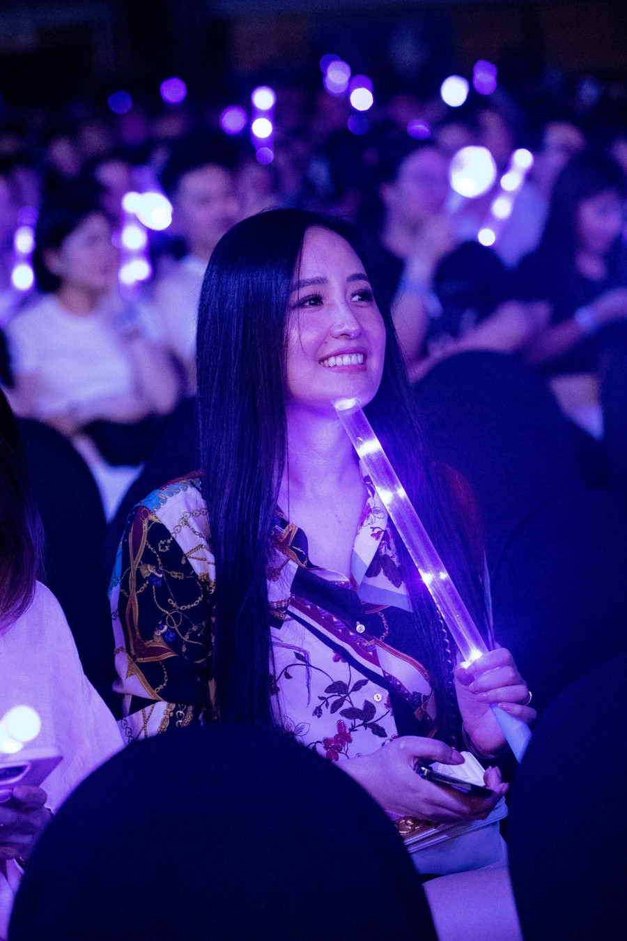 Mai Phương Thúy diện áo sơ mi in hoa đến đêm nhạc. Cô trang điểm nhẹ, mang theo lightstick ủng hộ Trung Quân.