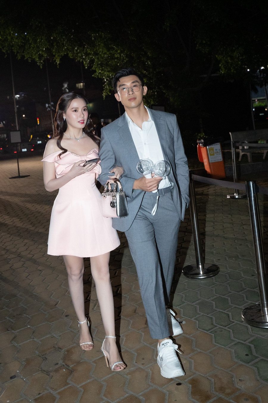 Khoảnh khắc Midu tay trong tay cùng Minh Đạt trước khi bước vào sân khấu thưởng thức âm nhạc. Nữ diễn viên mặc trang phục hồng nữ tính, trang điểm ngọt ngào, trong khi Minh Đạt mặc vest trẻ trung.