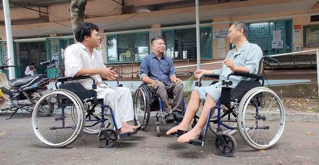 Sau giờ làm việc, anh Đặng Văn Trường (giữa) là tình nguyện viên tư vấn đồng đẳng cho bệnh nhân tổn thương tủy sống. Ảnh: NHƯ LỊCH