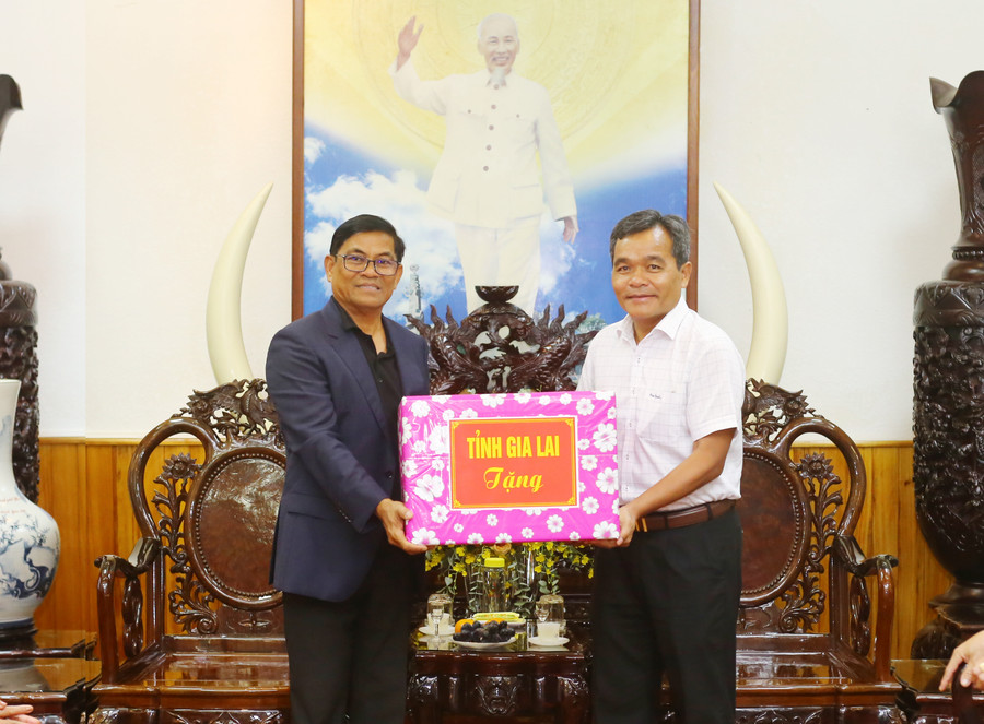 Đồng chí Bí thư Tỉnh ủy Hồ Văn Niên (bía phải) tặng quà cho Ngài Nhem Som Ươn. Ảnh: Đăng Vũ