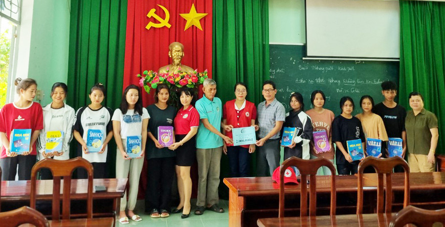 Đoàn công tác tặng sách giáo khoa và vở cho học sinh khó khăn của Trường Tiểu học và THCS Trạm Lập, xã Sơn Lang, huyện Kbang. Ảnh: Mai Anh