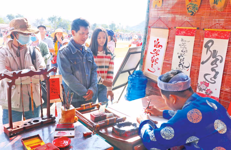 Du khách xin chữ ông đồ đầu năm tại lễ hội cầu huê. Ảnh: Ngọc Minh Du khách xin chữ ông đồ đầu năm tại lễ hội cầu huê. Ảnh: Ngọc Minh