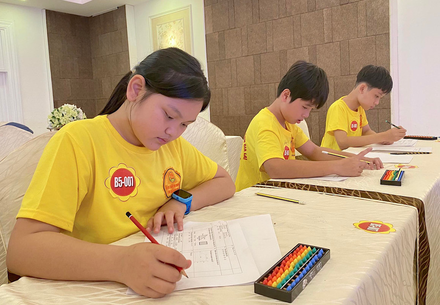 Em Lương Duy Gia Linh (bìa trái)-Lớp 6B, Trường THCS Đề Thám (thị xã An Khê) tập trung hoàn thành bài thi Toán bàn tính. Ảnh: Mộc Trà Em Lương Duy Gia Linh (bìa trái)-Lớp 6B, Trường THCS Đề Thám (thị xã An Khê) tập trung hoàn thành bài thi Toán bàn tính. Ảnh: Mộc Trà