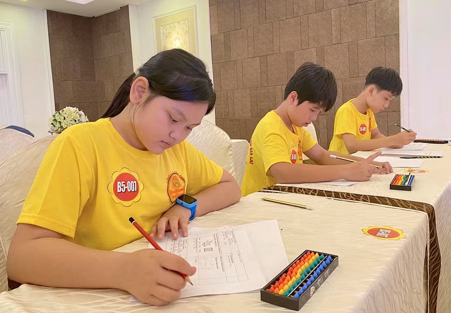 Em Lương Duy Gia Linh (bìa trái)-Lớp 6B, Trường THCS Đề Thám (thị xã An Khê) tập trung hoàn thành bài thi Toán bàn tính. Ảnh: Mộc Trà