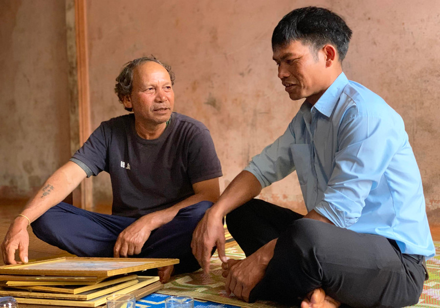 Ông Siu Mak (bìa trái) chia sẻ với ông Puih Lin kinh nghiệm tuyên truyền, vận động người dân chăm lo phát triển kinh tế. Ảnh: Nhật Hào