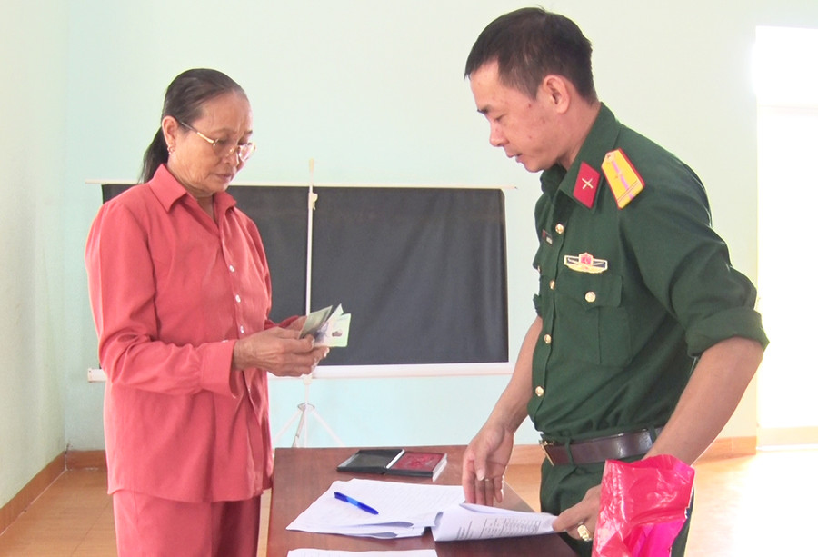 Bà Đặng Thị Kim Dung (thôn Chư Bồ 1, xã Ia Kla) nhận tiền trợ cấp của nhà nước. Ảnh: Phạm Ngọc