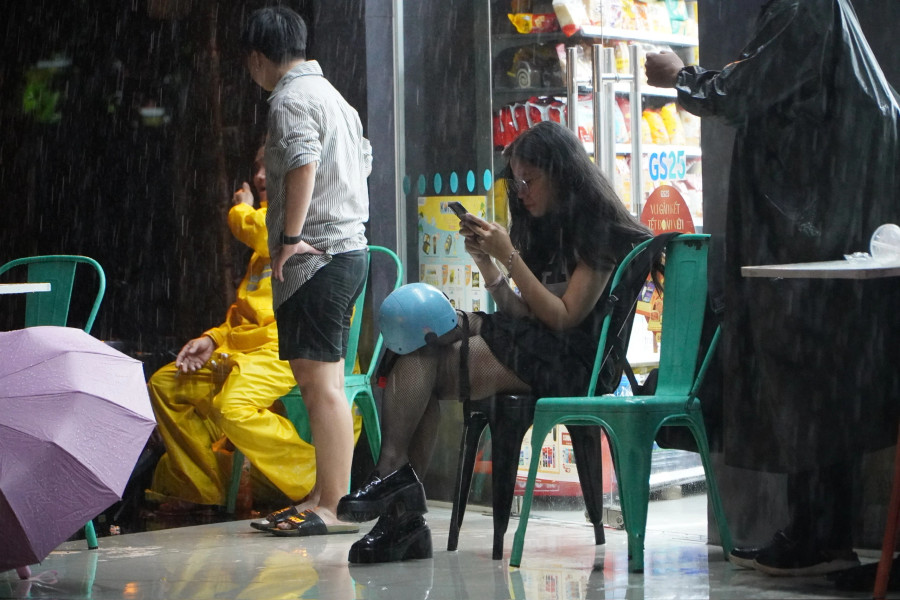 Người dân núp mưa, tránh ngập trước hiên nhà ven đường. Người dân núp mưa, tránh ngập trước hiên nhà ven đường.