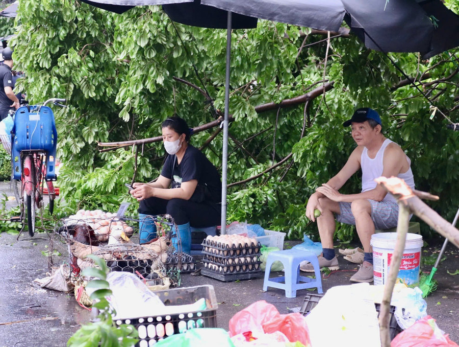 Chị Vũ Thị Gái tiểu thương bán rau tại chợ Dương Quảng Hàm cho biết: &quot;Tuy hôm nay là cuối tuần nhưng sức mua giảm nhiều so với trước, một phần do trời mới mưa bão người dân cũng chưa ra đường nhiều, một phần do trước đó người dân đã đi mua đồ tích trữ mấy ngày liền nên hôm nay ít người đi mua&quot;. Chị Gái cho biết, trước khi bão đổ bộ Hà Nội, cửa hàng chị bán được gấp 4 - 5 lần ngày thường, có lúc còn cháy hàng không có mà bán.