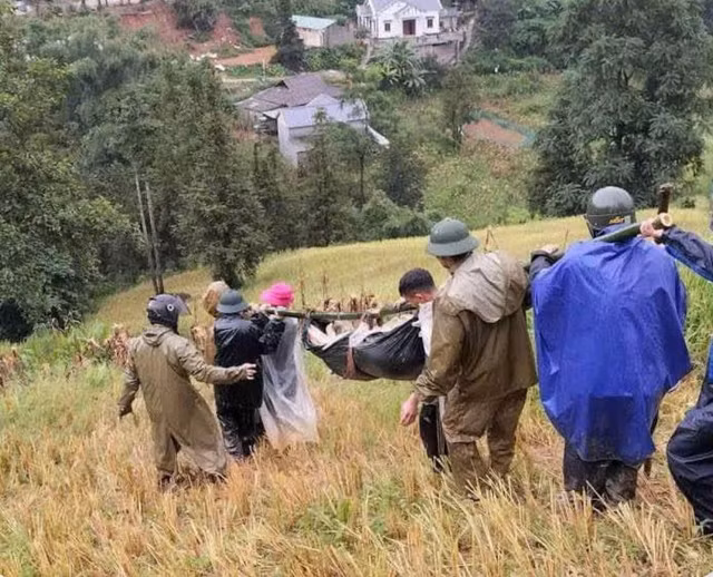 Các lực lượng chức năng đưa nạn nhân ra khỏi hiện trường vụ sạt lở