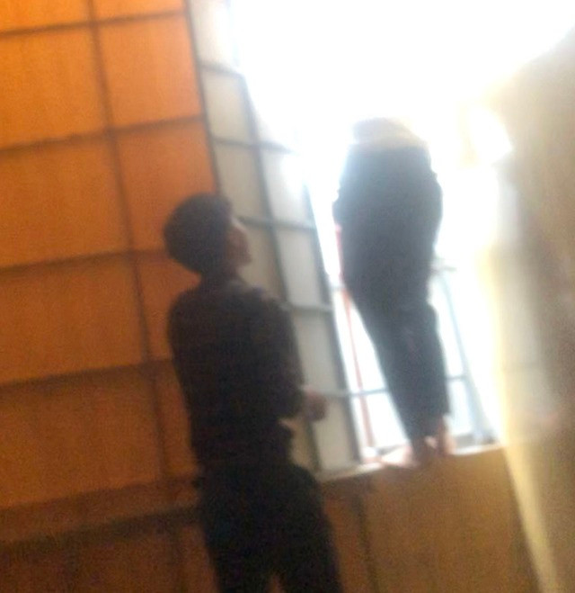 Bác sĩ H.V.L (phải) leo cửa sổ trốn ra mái tôn khi đoàn thanh tra đến kiểm tra