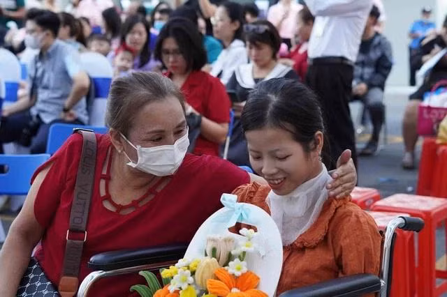 Mai Trang (phải) mang những giỏ hoa kẽm nhung đến BV tặng các BS