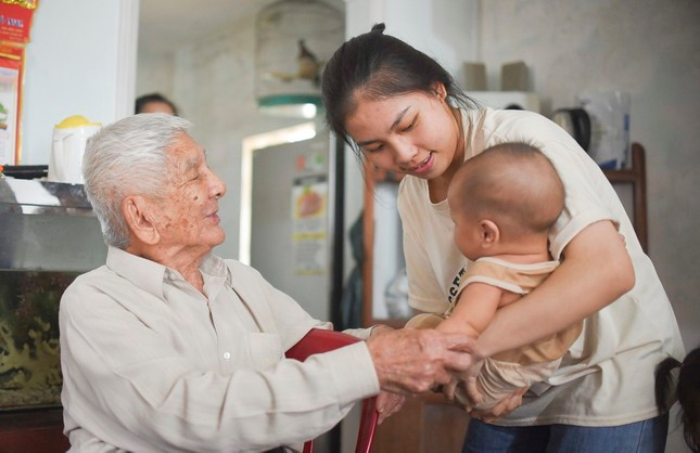 Ông Hiến hạnh phúc bên người cháu (gọi là ông cố). Ảnh: Trương Định