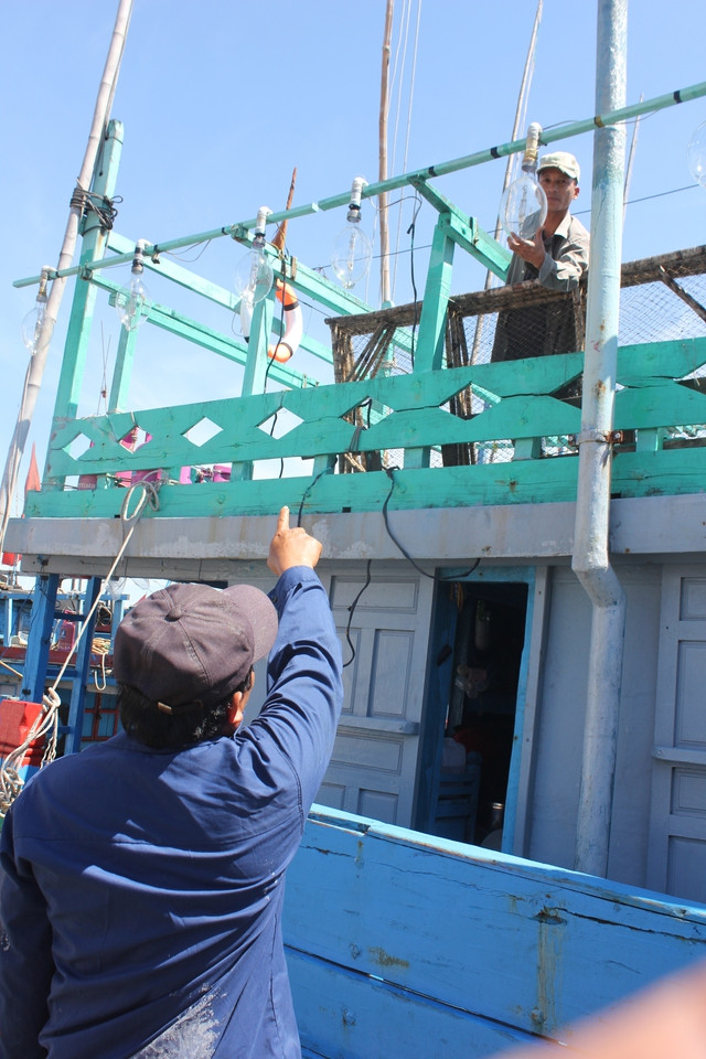 Ngư dân Trần Cu Anh và ngư dân Lê Tấn Thành kiểm tra giàn đèn trên tàu trước giờ xuất phát Ngư dân Trần Cu Anh và ngư dân Lê Tấn Thành kiểm tra giàn đèn trên tàu trước giờ xuất phát