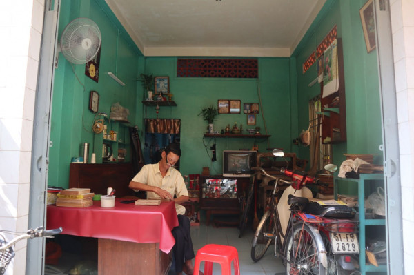 Bàn làm việc của ông Rạng đặt ngay trước cửa nhà.