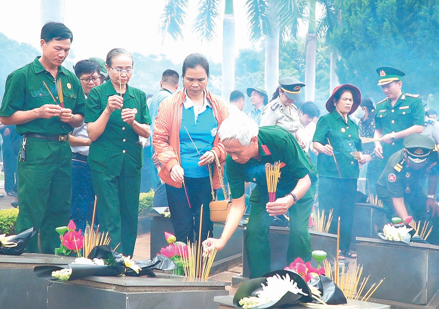 Cựu chiến binh và người dân thắp nến tri ân các liệt sĩ. Ảnh: Đức Thụy