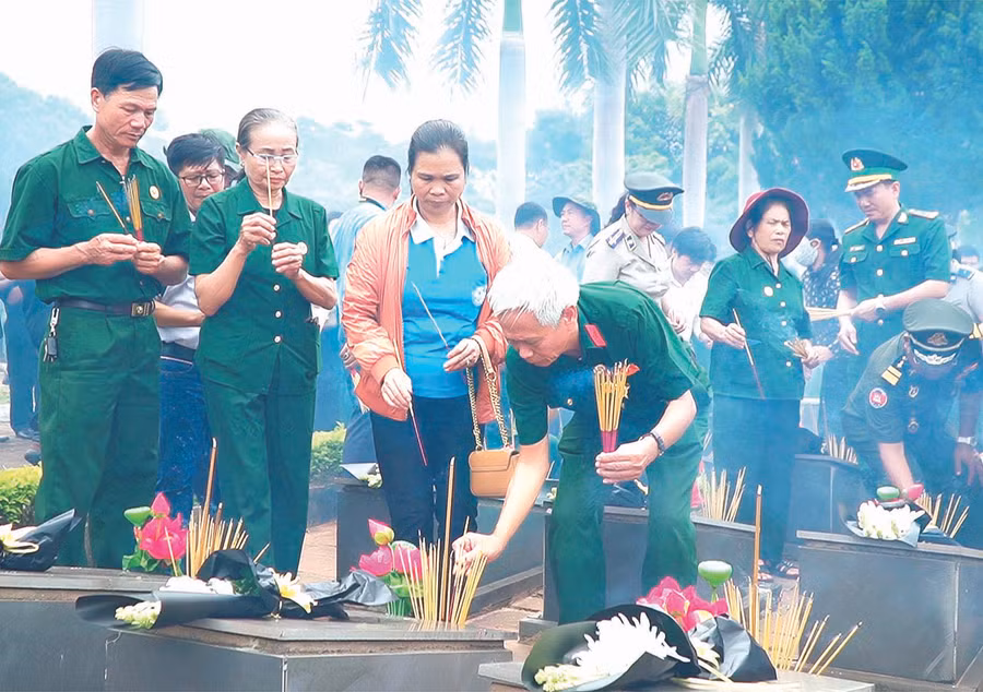Cựu chiến binh và người dân thắp nến tri ân các liệt sĩ. Ảnh: Đức Thụy