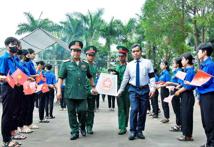 Đồng chí Hồ Văn Niên-Ủy viên Ban Chấp hành Trung ương Đảng, Bí thư Tỉnh ủy, Chủ tịch HĐND tỉnh (bên phải) và Trung tướng Trịnh Đình Thạch-Chính ủy Quân khu 5 (bên trái) di chuyển hài cốt liệt sĩ về vị trí an táng. Ảnh: Đức Thụy