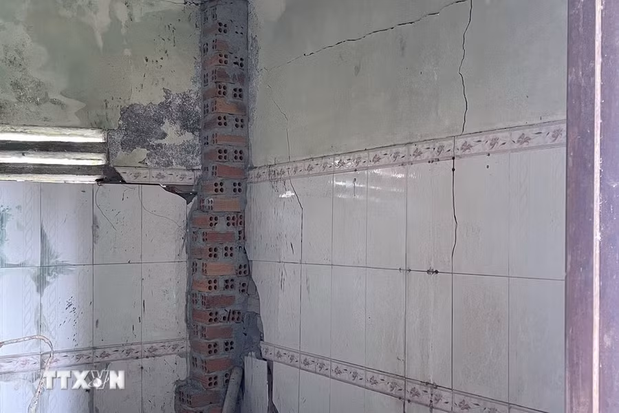 Nhiều ngôi nhà bị nứt, hư hỏng do ảnh hưởng của việc tuyến đường bên trên sụt lún, sạt trượt. (Ảnh: Minh Hưng/TTXVN)