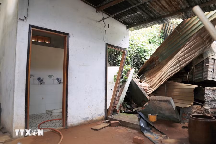 Nhiều ngôi nhà bị nứt, hư hỏng do ảnh hưởng của việc tuyến đường bên trên sụt lún, sạt trượt. (Ảnh: Minh Hưng/TTXVN)