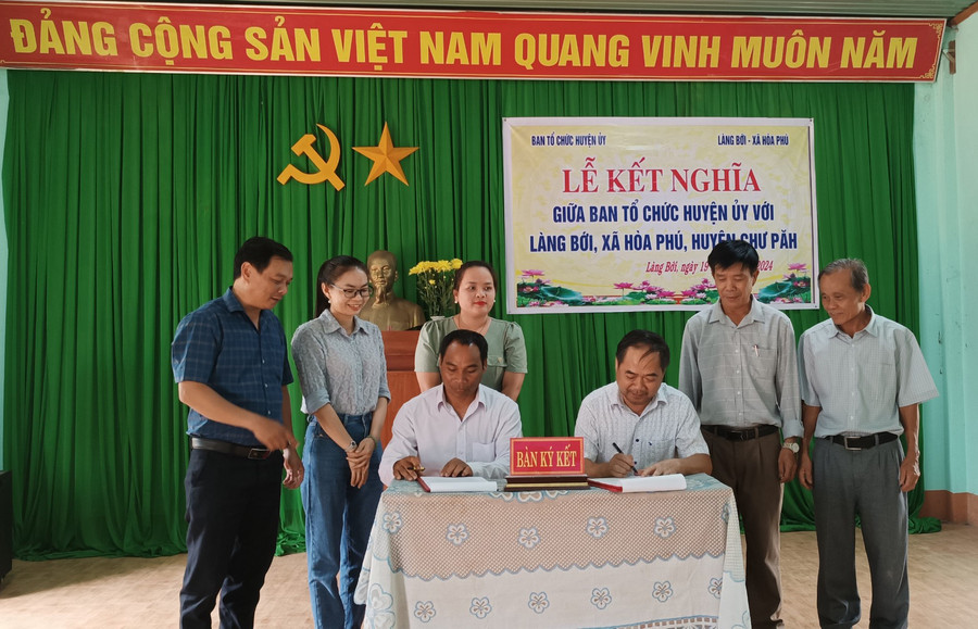 Đại diện Ban Tổ chức Huyện ủy Chư Păh và làng Bới ký bản giao ước kết nghĩa. Ảnh: V.Đ Đại diện Ban Tổ chức Huyện ủy Chư Păh và làng Bới ký bản giao ước kết nghĩa. Ảnh: V.Đ