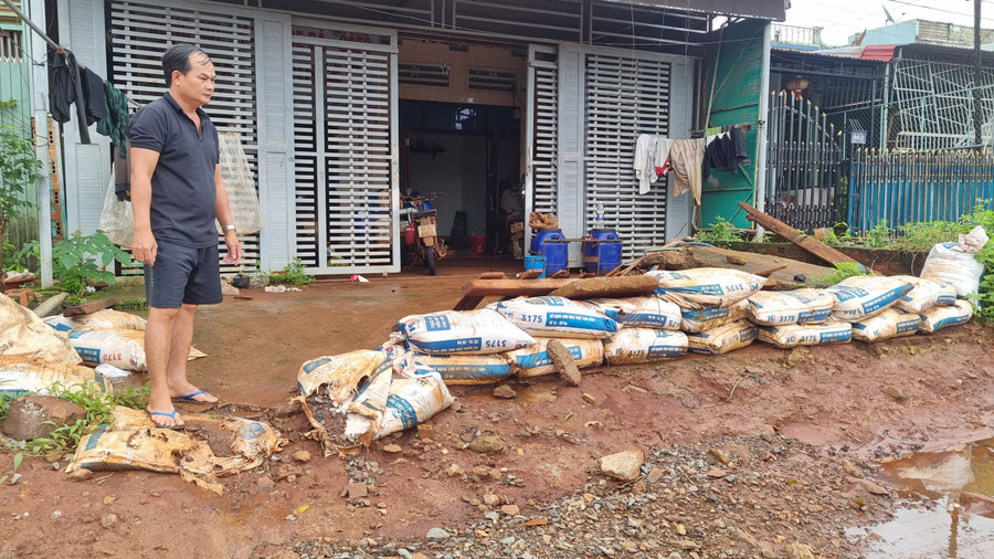 Người dân nơi đây dùng bao cát, đắp kè chắn trước cổng nhà để ngăn nước. Ảnh: Hà Phương