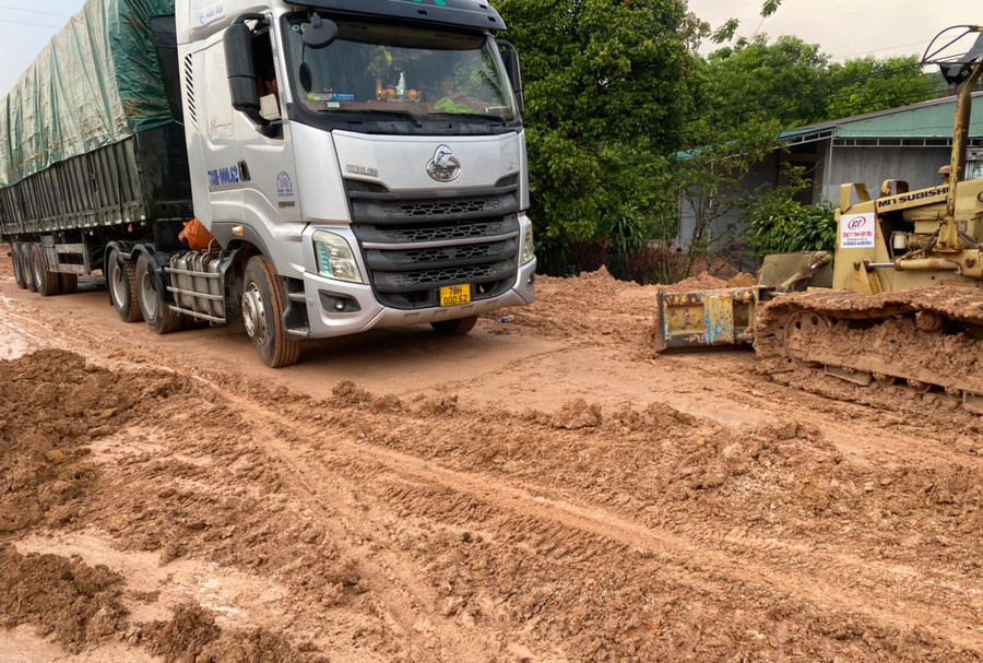 Bùn đất tràn ra mặt đường gây sình lầy, khiến người và phương tiện lưu thông bị ách tắc. Ảnh: Văn Trí