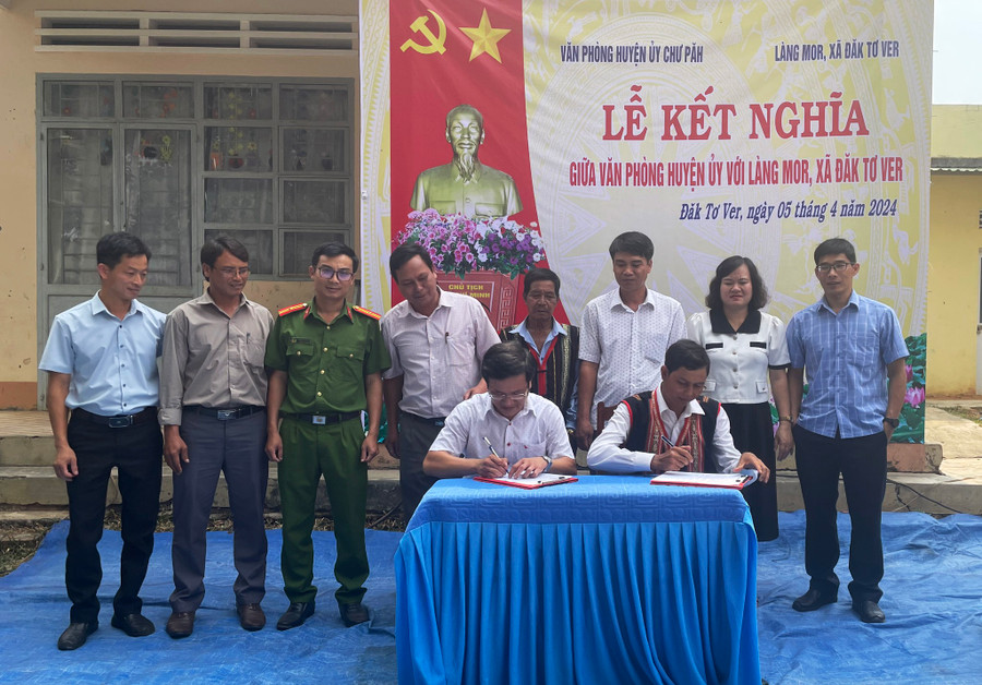 Đại diện Văn phòng Huyện ủy Chư Păh và làng Mor ký kết bản giao ước kết nghĩa. Ảnh: V.Đ