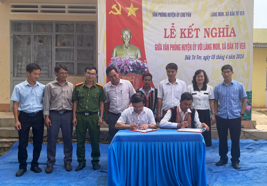 Đại diện Văn phòng Huyện ủy Chư Păh và làng Mor ký kết bản giao ước kết nghĩa. Ảnh: V.Đ