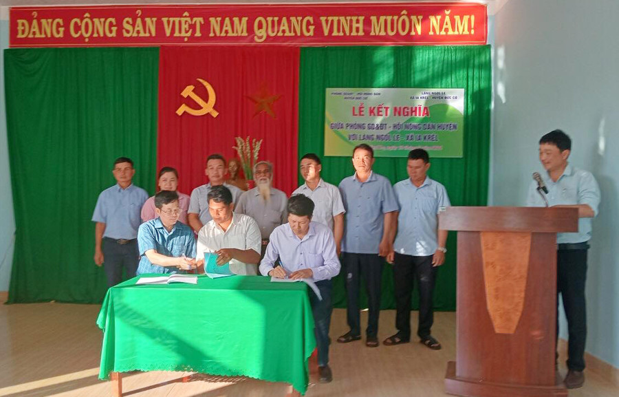 Đại diện Hội Nông dân huyện, Phòng Giáo dục và Đào tạo huyện Đức Cơ và làng Ngo Le ký bản giao ước kết nghĩa. Ảnh: N.T