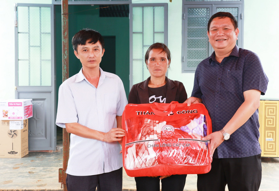 Đại diện chính quyền địa phương tặng cho gia đình bà Thap một số vật dụng thiết yếu dùng cho sinh hoạt gia đình. Ảnh: Lê Hùng