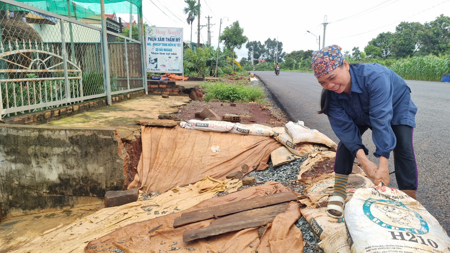 Nguyễn Thị Sáng (tổ dân phố 7, thị trấn Chư Ty) phải dùng những bao cát để che chắn không cho nước chảy vào nhà. Ảnh: Hà Phương