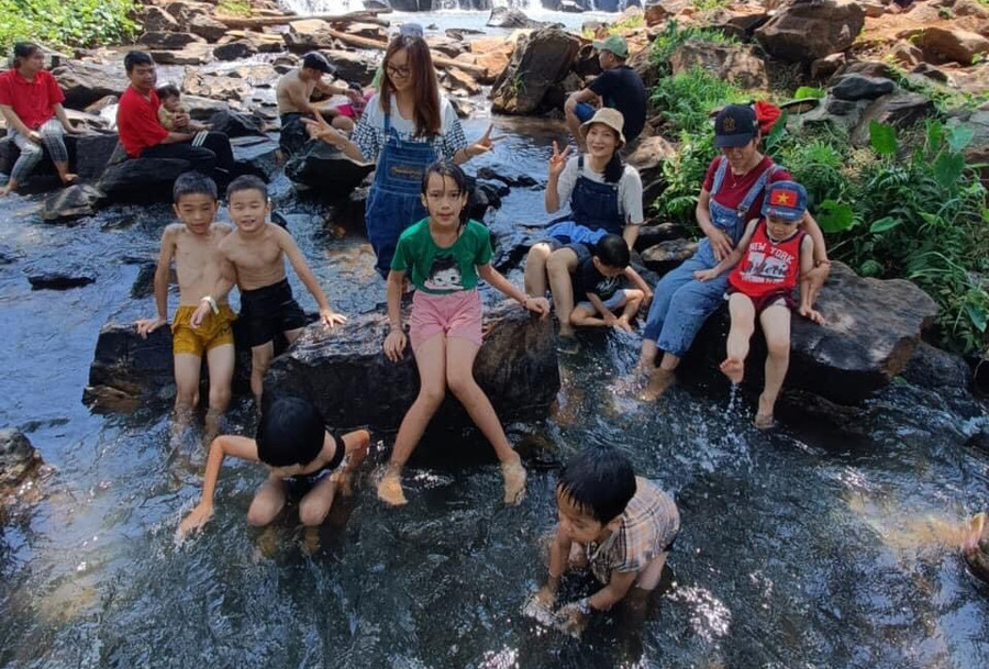 Du khách chụp ảnh lưu niệm bên con thác.